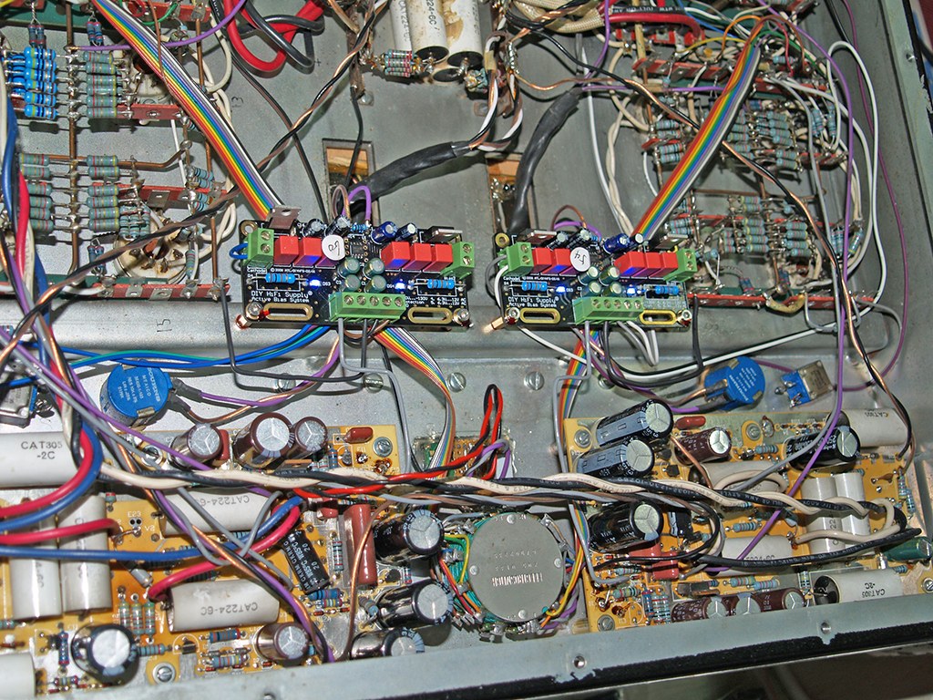 Photograph: close-up of the underside with the automatic bias modules, black boards with red WIMA capacitors and blue indicator lights, mounted among the original wiring